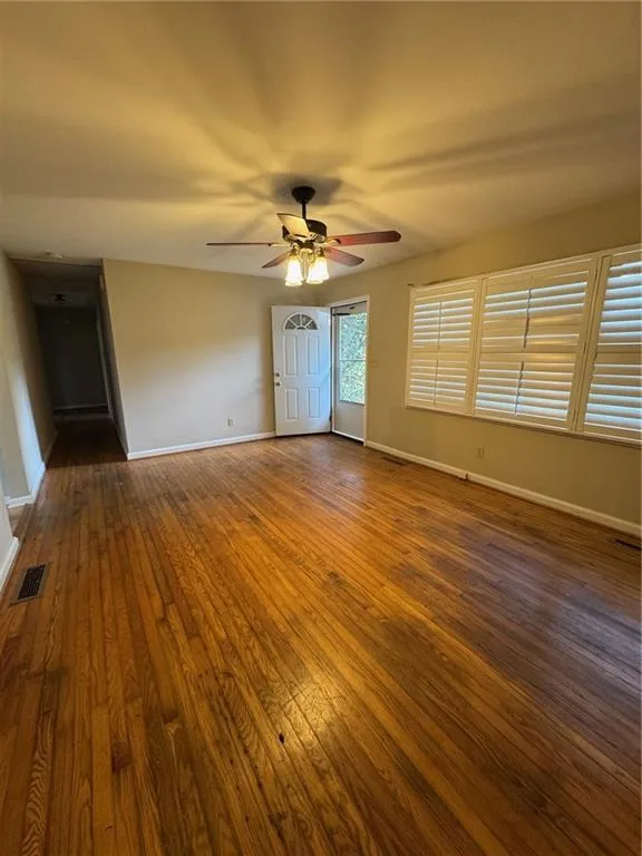 Spare room with dark wood-style flooring and ceiling fan