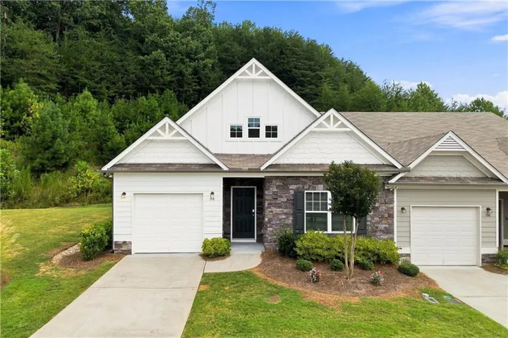 Craftsman-style exterior featuring stone accents, board and batten siding, and a single-car garage
