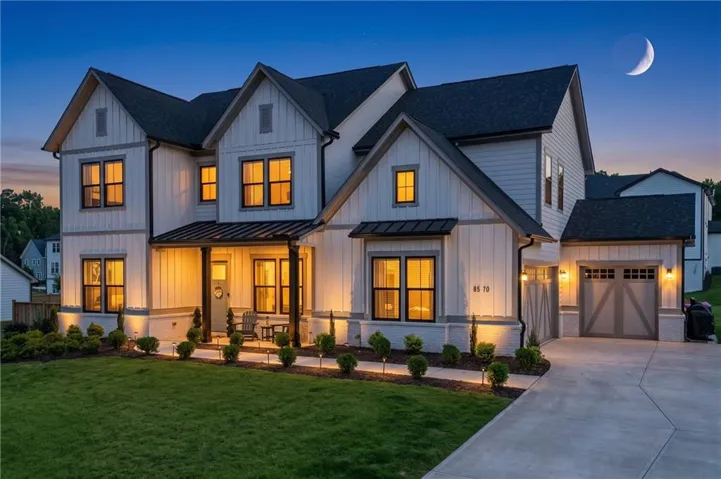 Farmhouse-style exterior with white siding, dark trim, and a covered porch