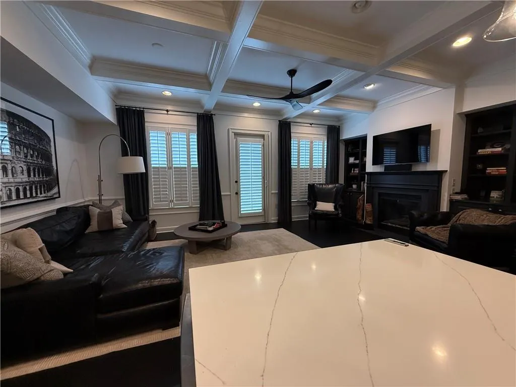 Bedroom with a fireplace, beamed ceiling, coffered ceiling, crown molding, and recessed lighting