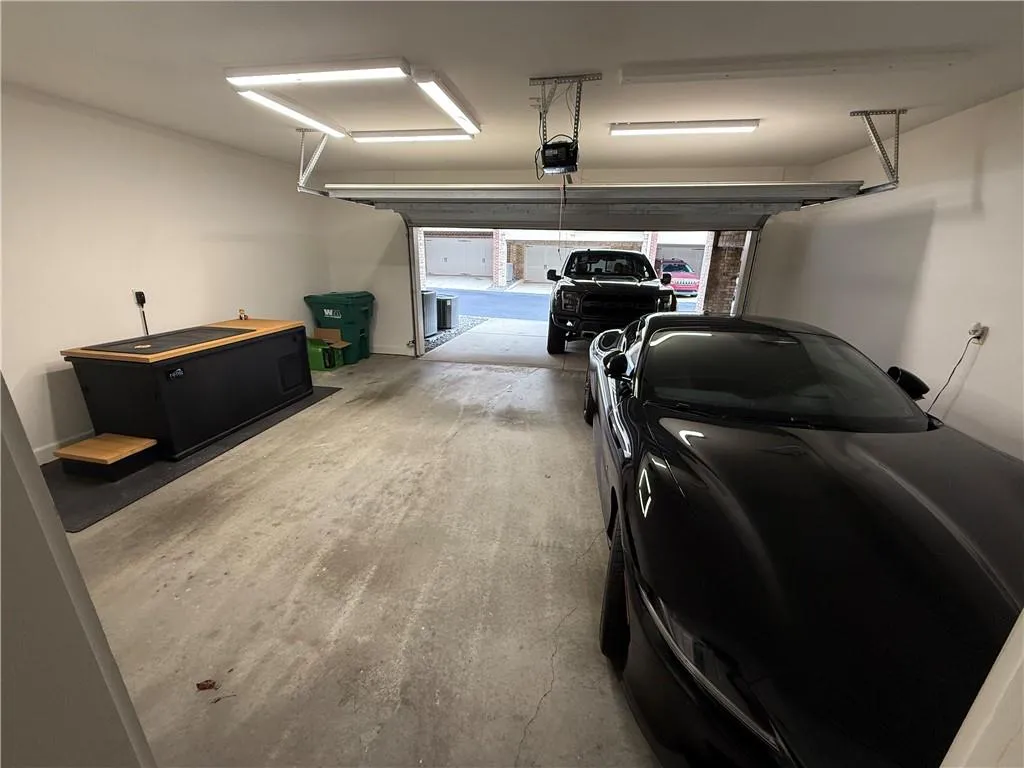 Garage featuring black fridge and a garage door opener