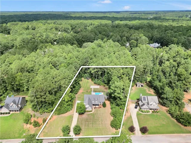 Expansive property featuring a private swimming pool, mature trees, a detached storage shed, and a circular driveway