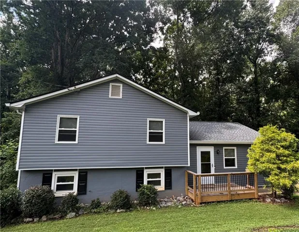 Gray siding exterior with white window trim and black shutters