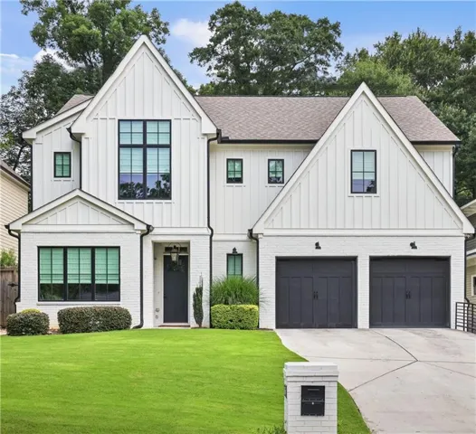Modern farmhouse exterior featuring white painted brick and board-and-batten siding