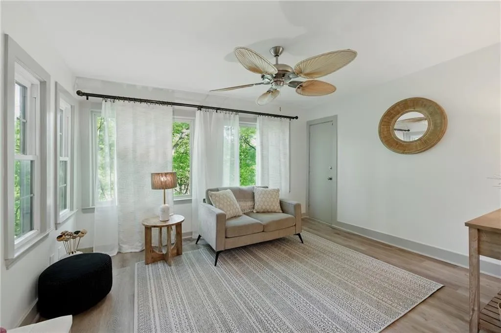 Living area with light wood-style floors and ceiling fan