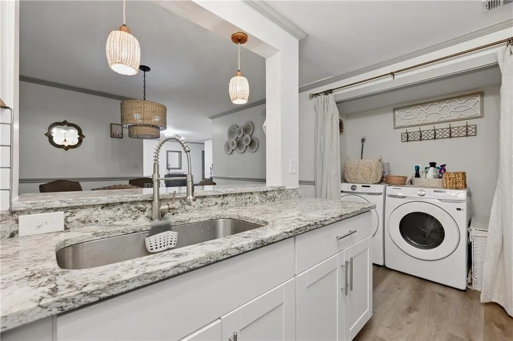 Laundry room with independent washer and dryer and light wood finished floors
