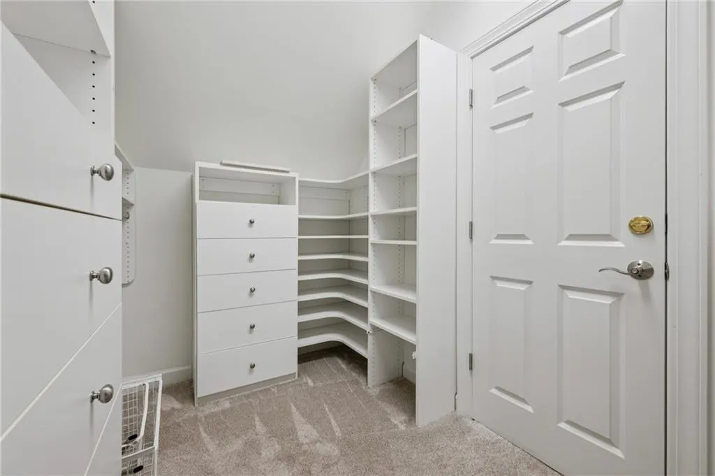 Walk in closet featuring light colored carpet