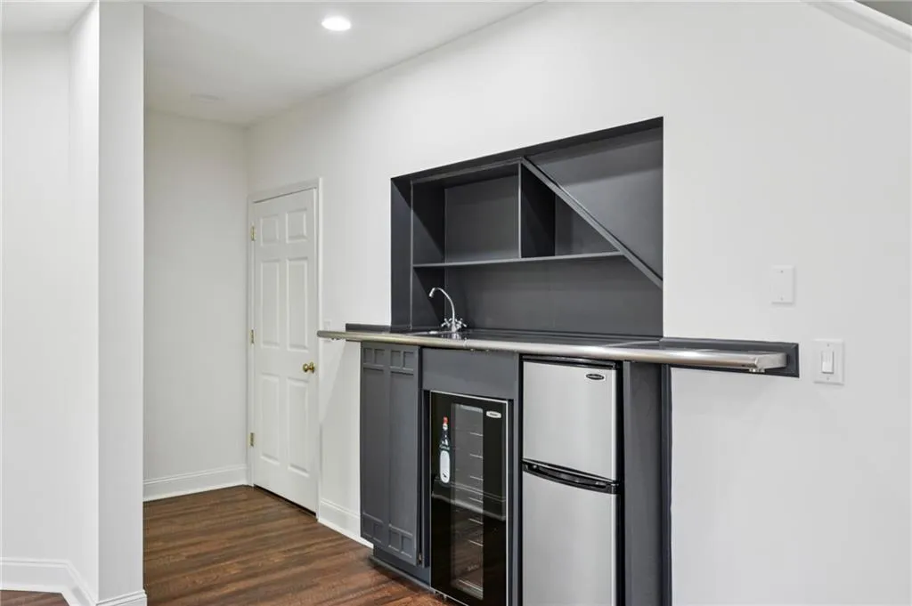 Indoor wet bar featuring wine cooler, freestanding refrigerator, dark wood-style floors, gray cabinets, and recessed lighting