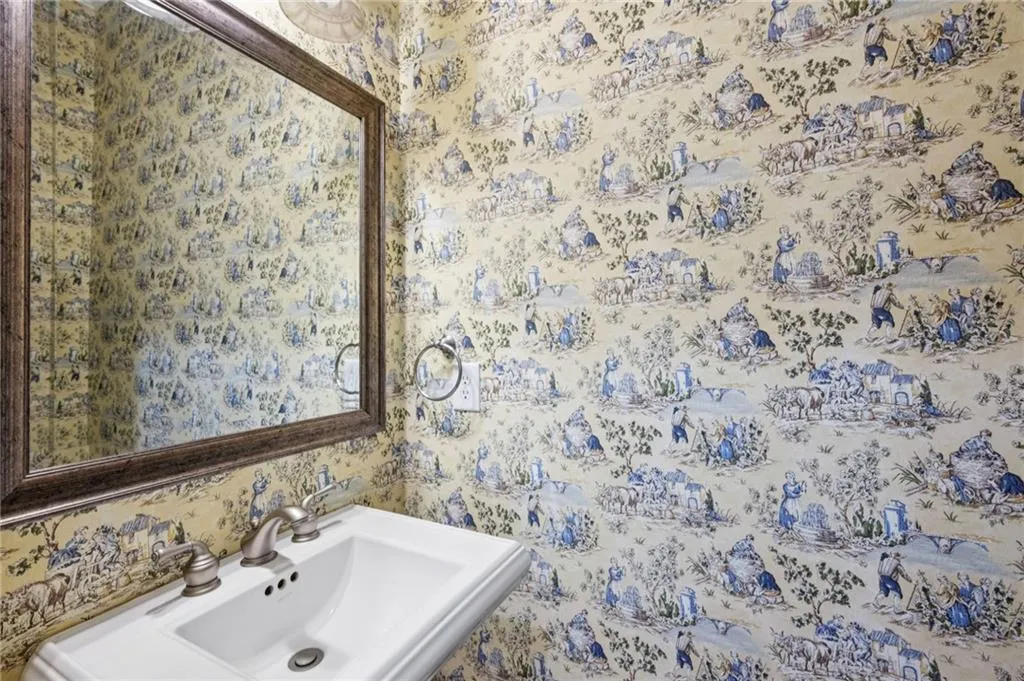 Bathroom with a sink and wallpapered walls