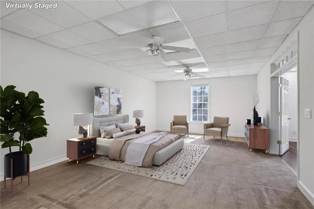 Carpeted bedroom with a paneled ceiling and ceiling fan