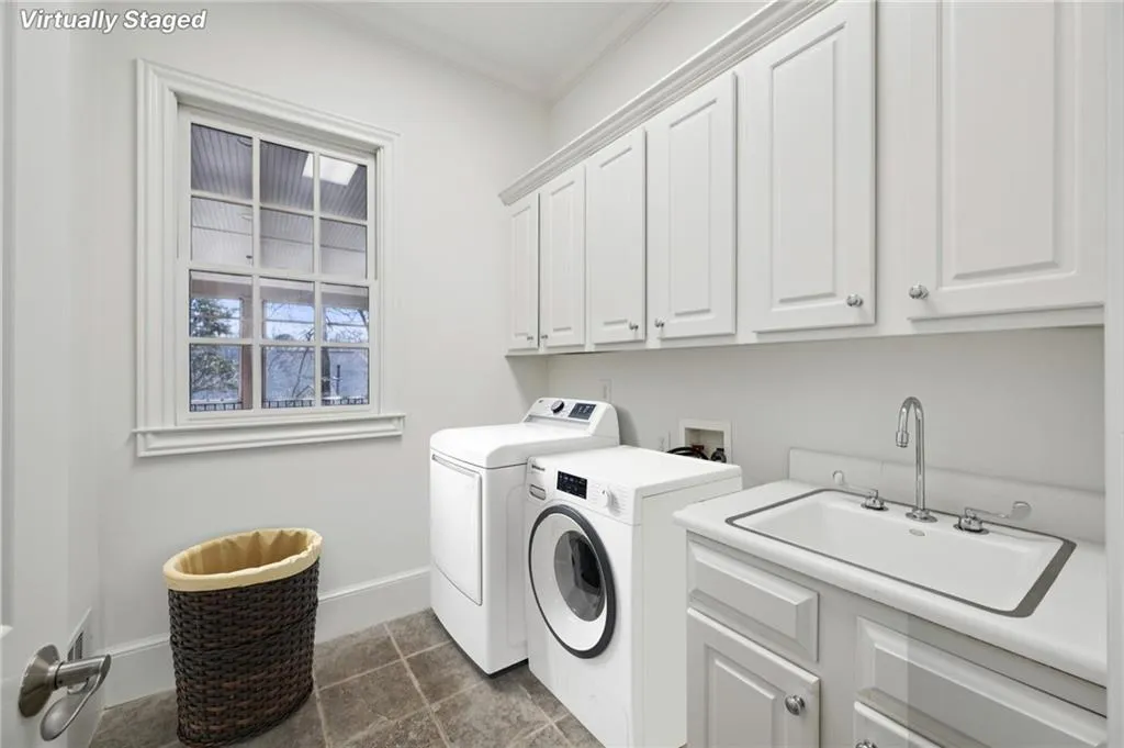Laundry room featuring washing machine and dryer, cabinet space, and ornamental molding