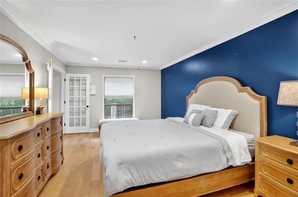 Bedroom with ornamental molding, light wood finished floors, and recessed lighting