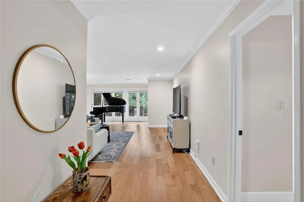 Hall with ornamental molding, light wood-type flooring, recessed lighting, and french doors