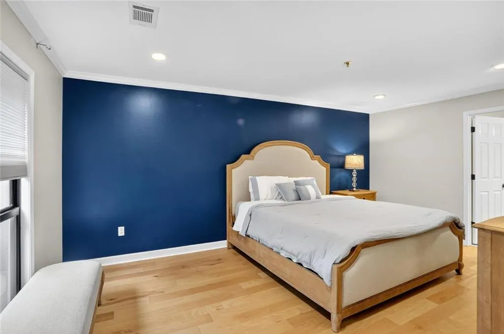 Bedroom featuring light wood-type flooring, crown molding, and recessed lighting
