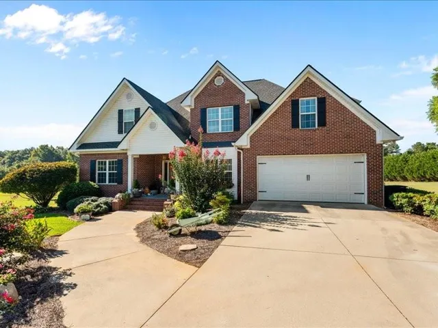 Brick exterior with gabled roof lines, attached two-car garage, and a covered front porch