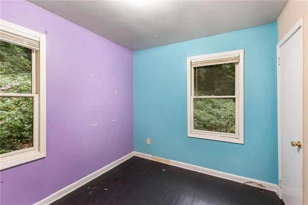 Empty room featuring baseboards and dark wood finished floors