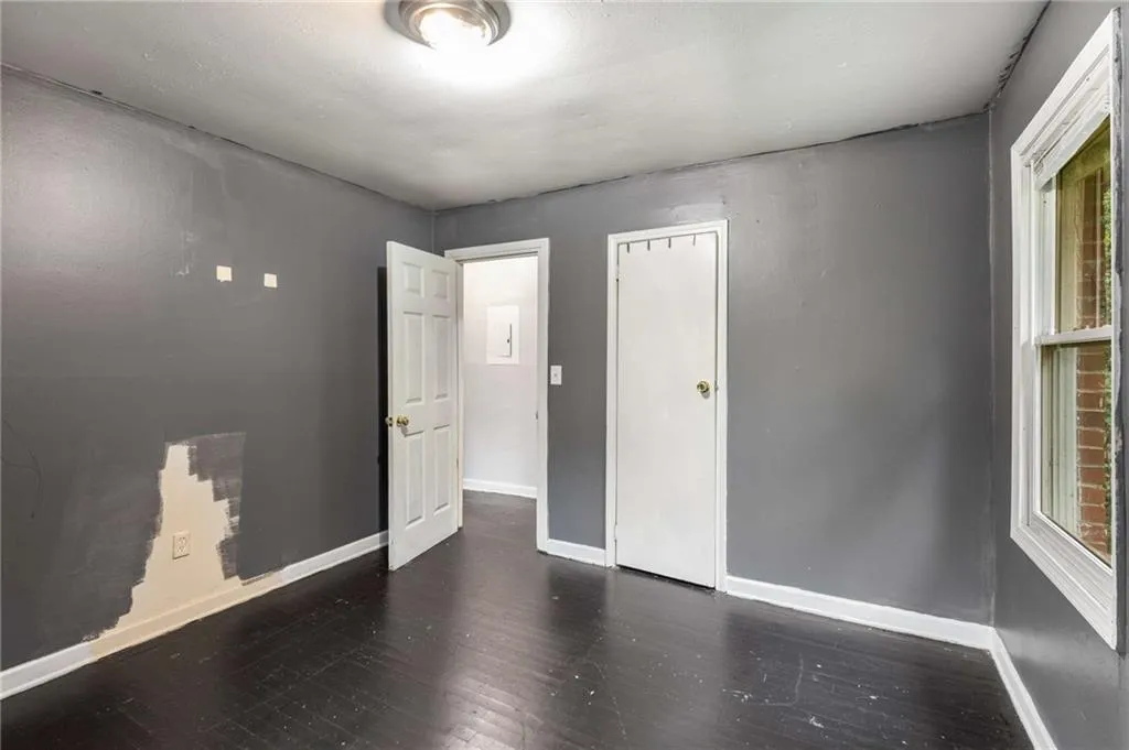 Unfurnished bedroom featuring dark wood finished floors and a closet