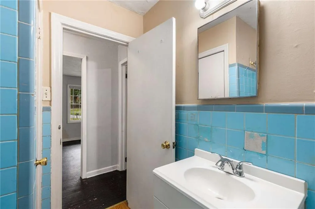 Bathroom featuring vanity, tile walls, and wood finished floors