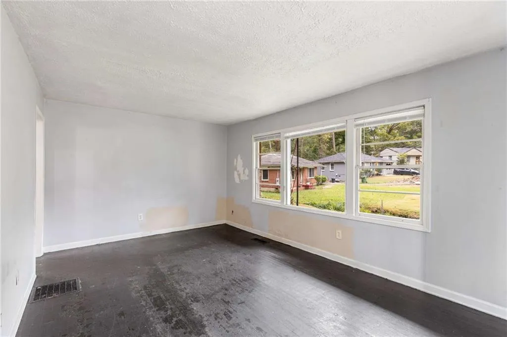 Spare room with baseboards and a textured ceiling