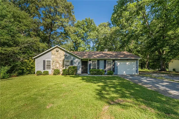 Charming single-story home featuring a mixed stone and siding exterior, updated roof, and two-car garage