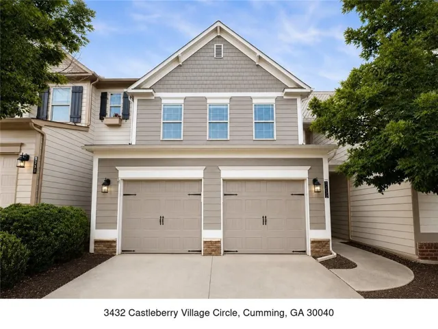 Two-story facade featuring horizontal siding and shake accents, with a prominent two-car garage