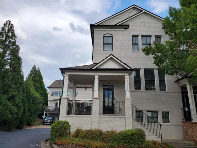 View of front of house featuring brick wall, covered porch