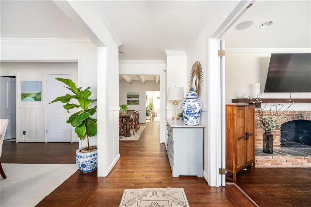 Hallway with dark wood-style floors and ornamental molding