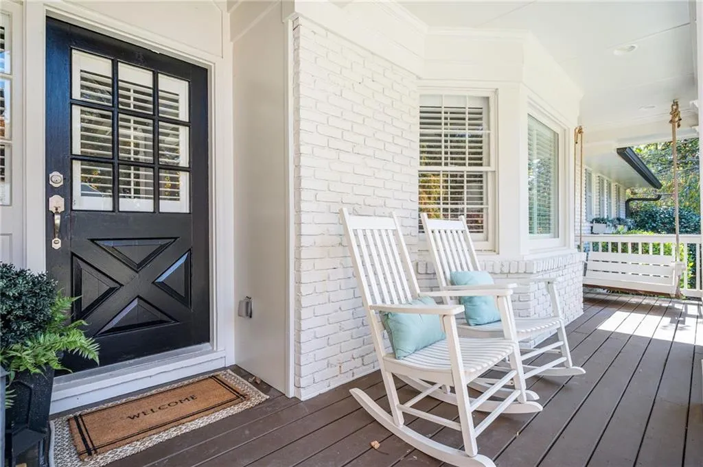 View of exterior entry featuring brick siding and covered porch