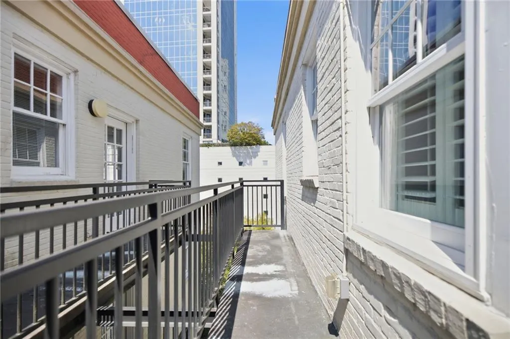 Exterior featuring painted brick, white trim, red shingle roof, and metal railings