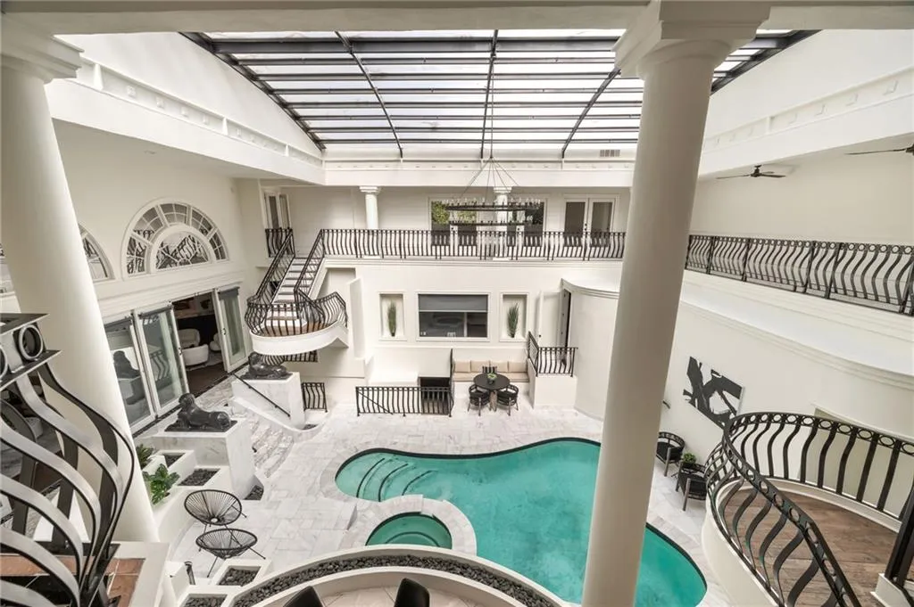 View of swimming pool featuring a pool with connected hot tub and decorative columns