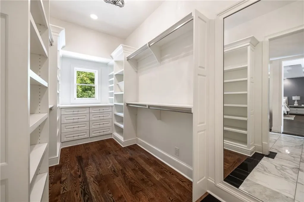 Walk in closet with dark wood finished floors