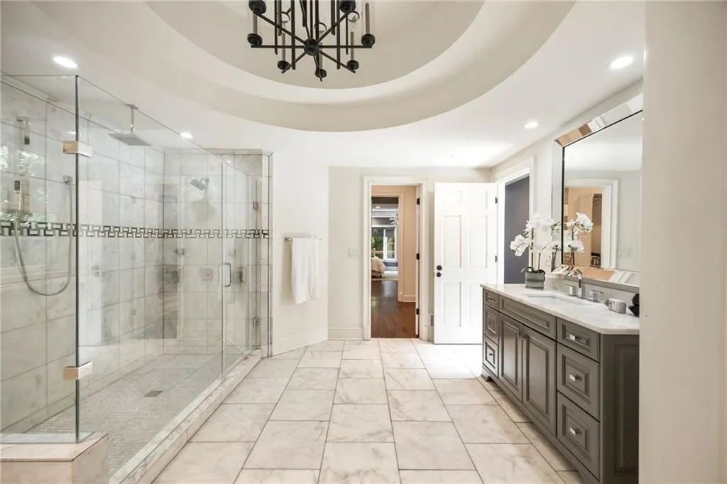 Bathroom with vanity, a shower stall, recessed lighting, a chandelier, and light marble finish flooring