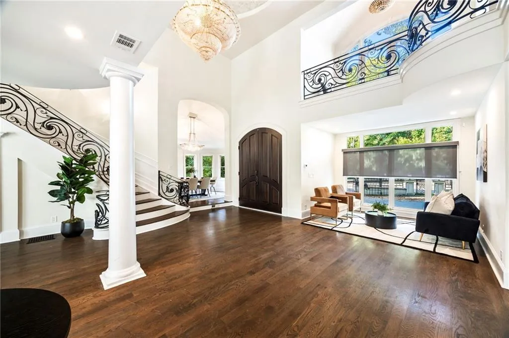 Foyer entrance with stairs, recessed lighting, dark wood-style floors, a towering ceiling, and arched walkways