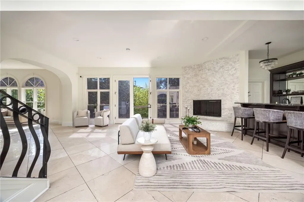 Living room featuring light tile patterned floors, healthy amount of natural light, and a chandelier