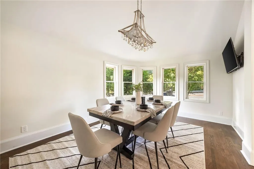 Dining area featuring dark wood-style floors and a chandelier