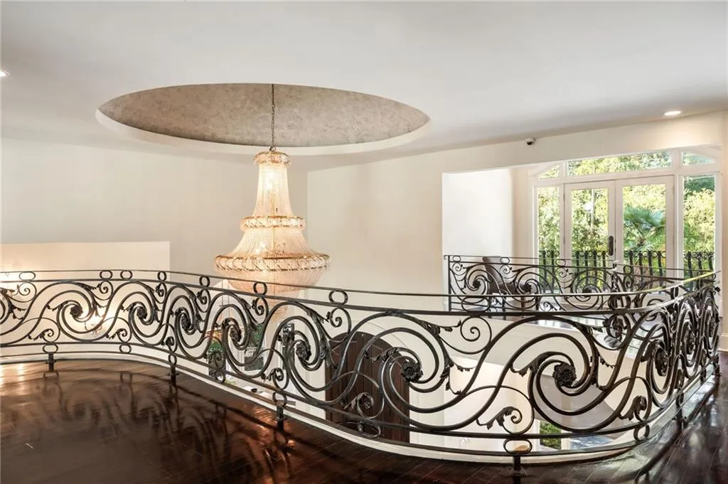 Detailed view of a tray ceiling, a chandelier, wood finished floors, and recessed lighting