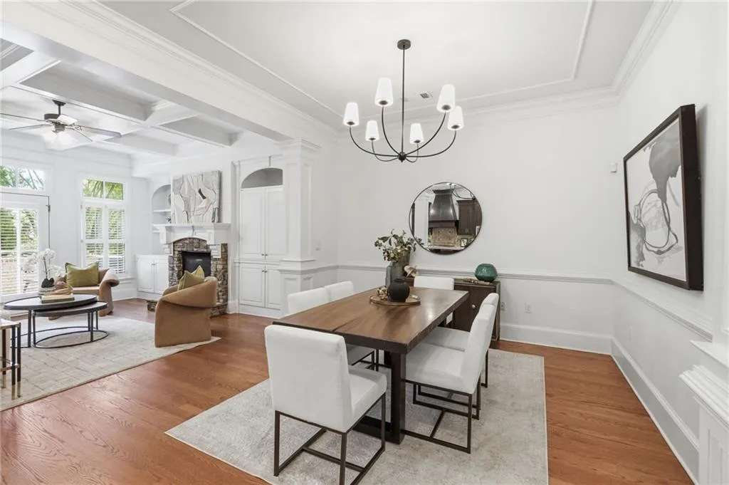 Dining area featuring a contemporary chandelier, crown molding, and wainscoting