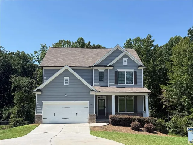 Two-story Colonial-style residence featuring a charcoal gray fiber cement exterior with white trim, pitched roofline with gabled details, and architectural symmetry