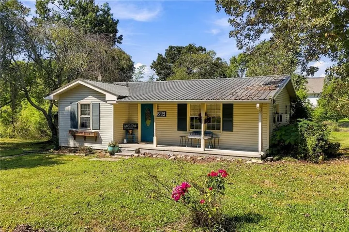 Horizontal siding exterior with a metal roof and covered front porch