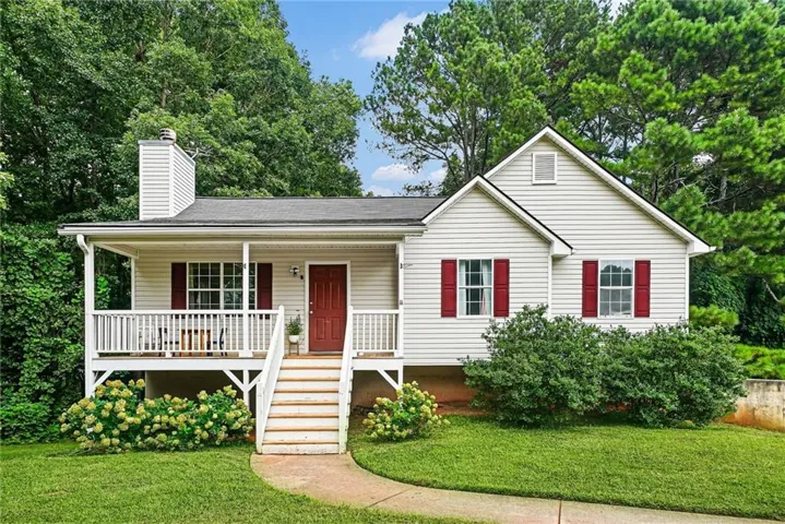 Siding exterior with red shutters, front porch with white railing, and a red entry door