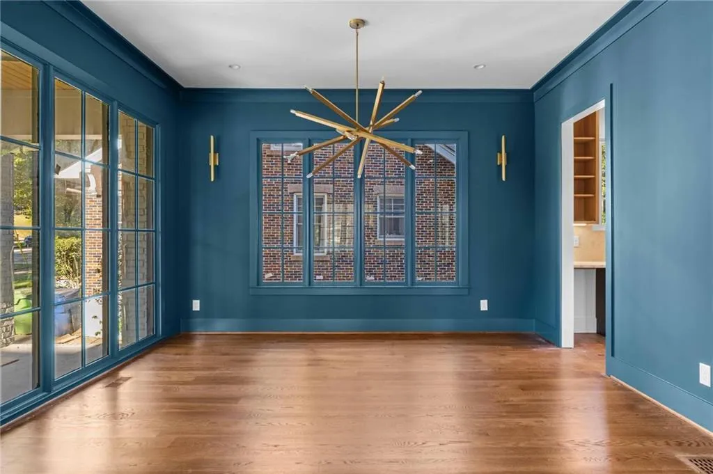 Unfurnished dining area with wood finished floors, a chandelier, and crown molding