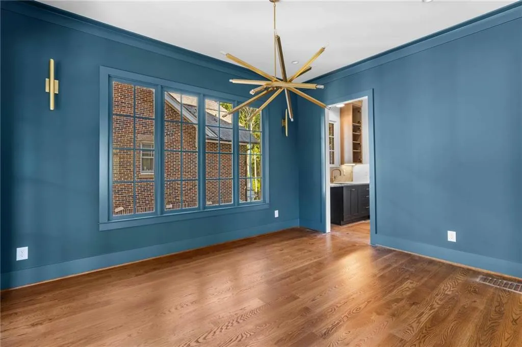 Unfurnished dining area with wood finished floors, a chandelier, and crown molding