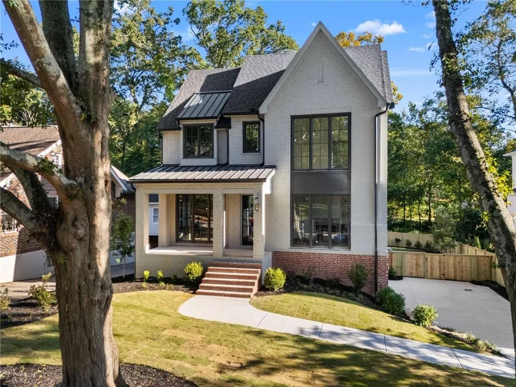 Modern farmhouse style home with a porch, brick siding, a standing seam roof, and a metal roof