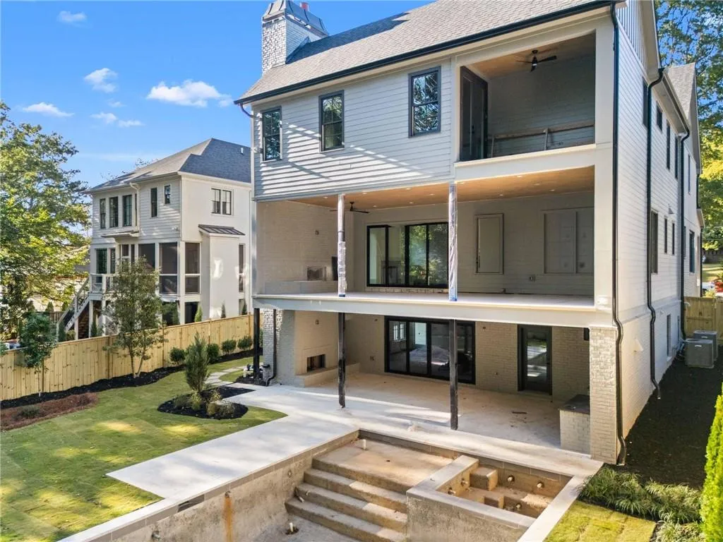 Rear view of property featuring a balcony, a chimney, a patio, and a ceiling fan