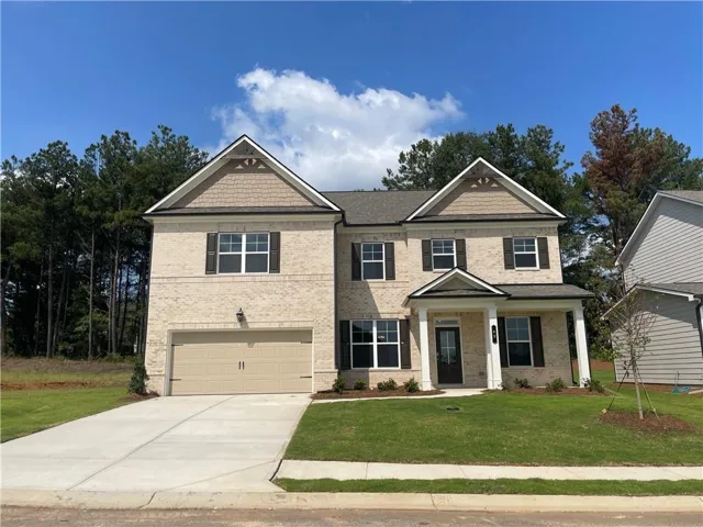 Brick exterior with contrasting shutters, covered front porch, attached garage, and a concrete driveway