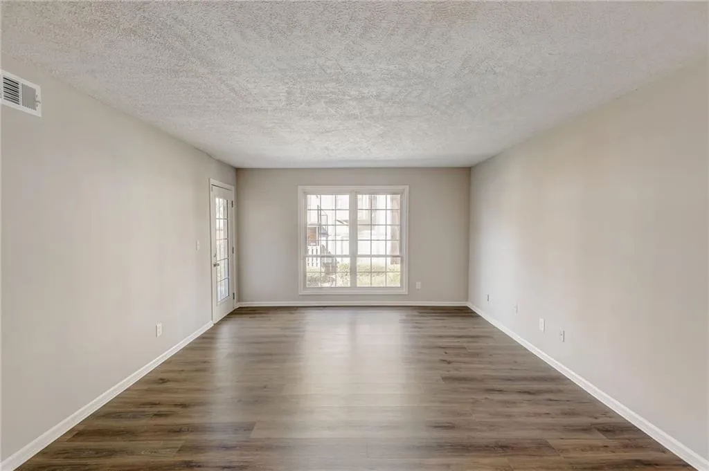 Unfurnished room with dark hardwood / wood-style floors and a textured ceiling
