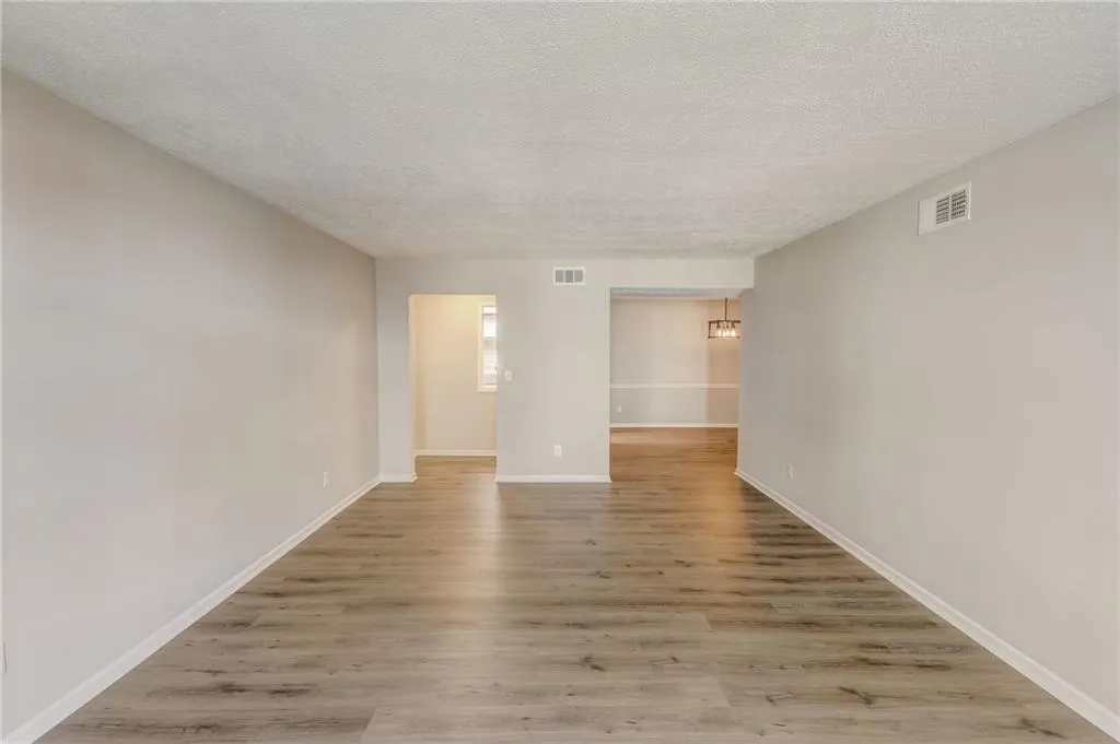 Unfurnished room featuring wood-type flooring and a textured ceiling