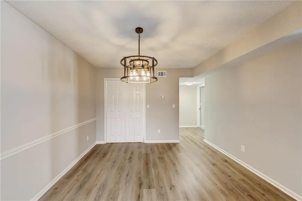 Unfurnished room featuring a notable chandelier and hardwood / wood-style flooring