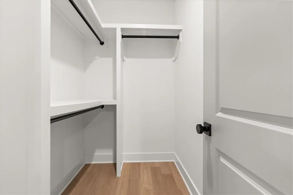 Walk in closet with light wood-style floors