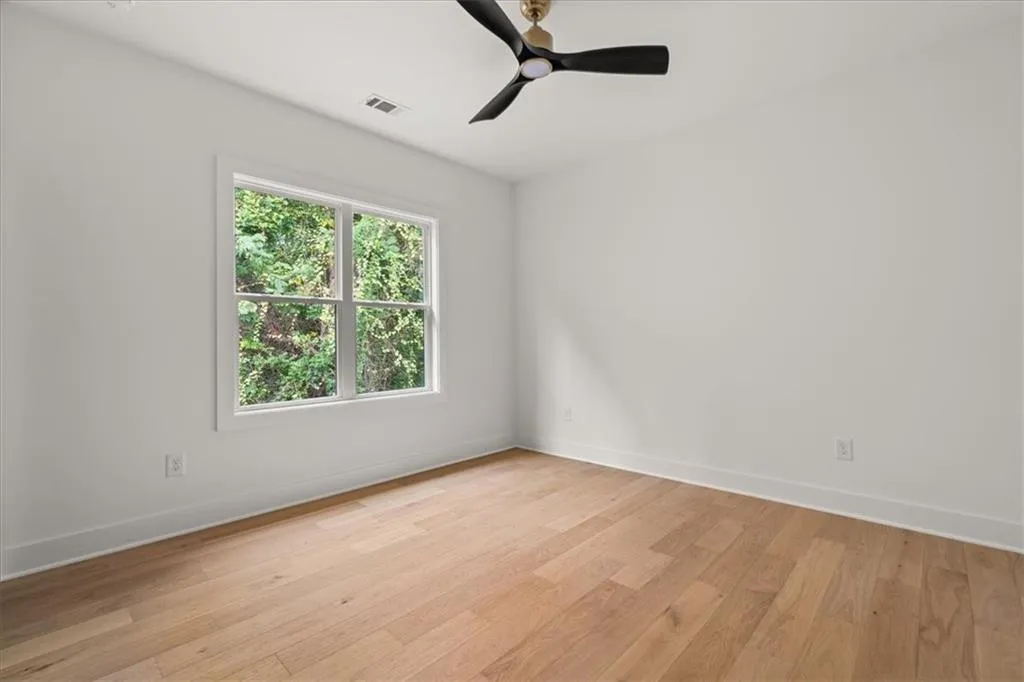 Unfurnished room with light wood finished floors and a ceiling fan